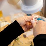 Frauenhände arbeiten an Zahnimplantat